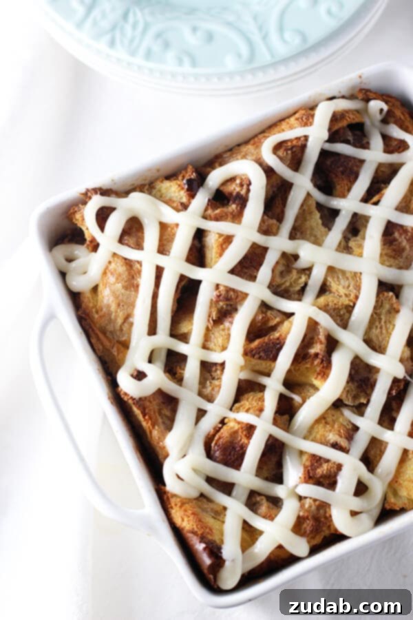 Gooey Caramel Cinnamon Roll Baked French Toast Casserole for breakfast or brunch Overhead view of Gooey Caramel Cinnamon Roll Baked French Toast Casserole, showcasing the generous frosting and golden crust