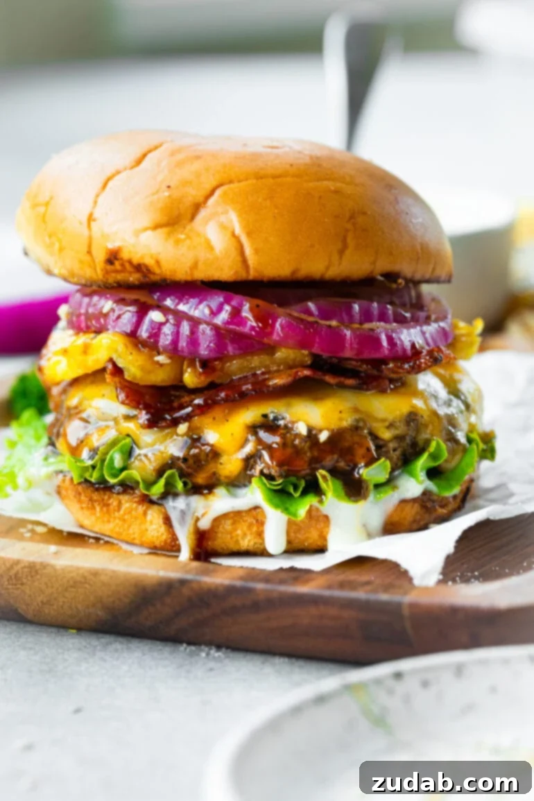 Teriyaki Pina Colada Burger 2 A vibrant, mouth-watering Teriyaki Pina Colada Burger, showcasing a perfectly cooked patty with melted Colby Jack cheese, crisp bacon, grilled pineapple, and a generous drizzle of creamy pina colada sauce, all nestled in a toasted brioche bun.