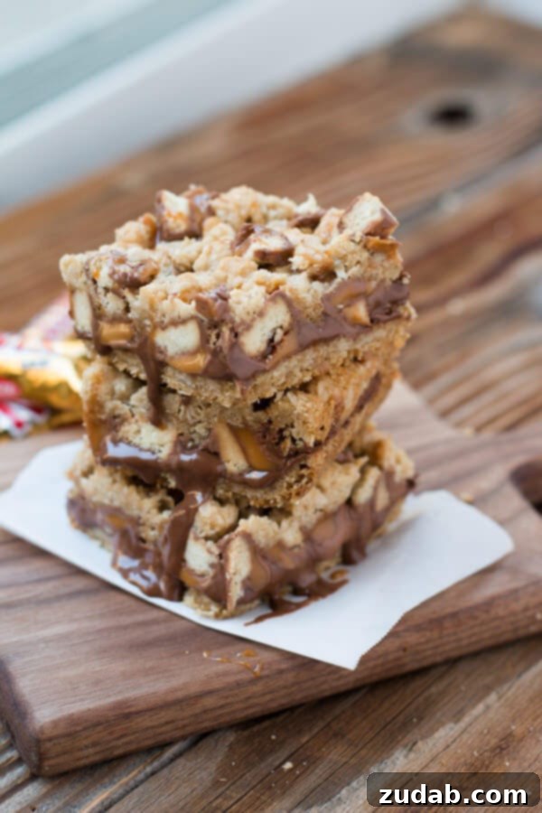 Easy Twix Caramelita Recipe Close-up of baked Twix Caramelitas, golden brown oatmeal crust with melted chocolate and caramel drizzle.