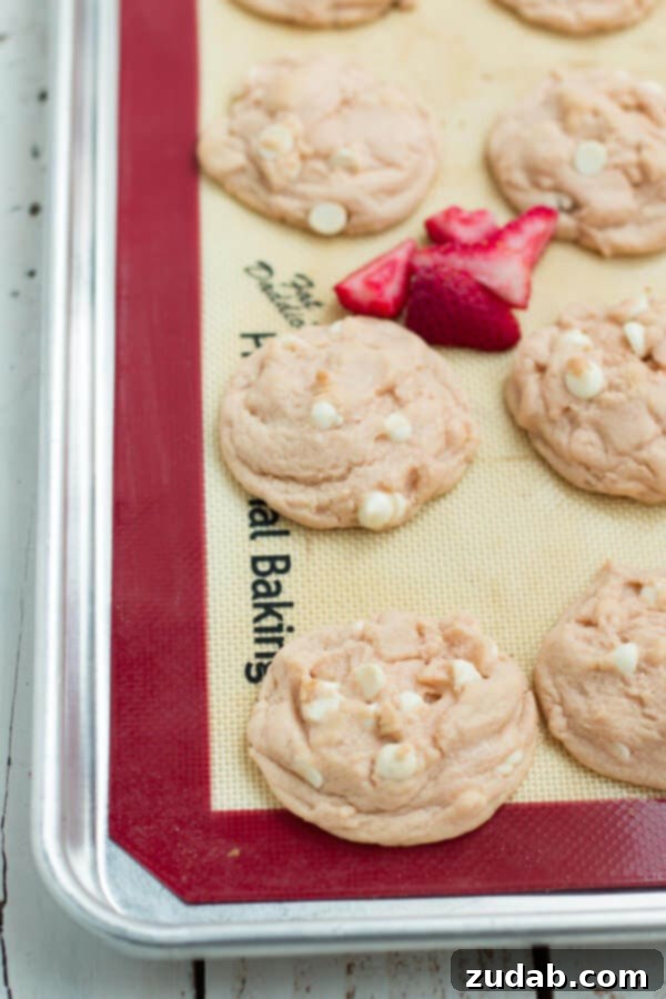 Irresistible Strawberries and Cream Pudding Cookies A close-up of a plate of Strawberries and Cream Pudding Cookies with white chocolate chips visible.