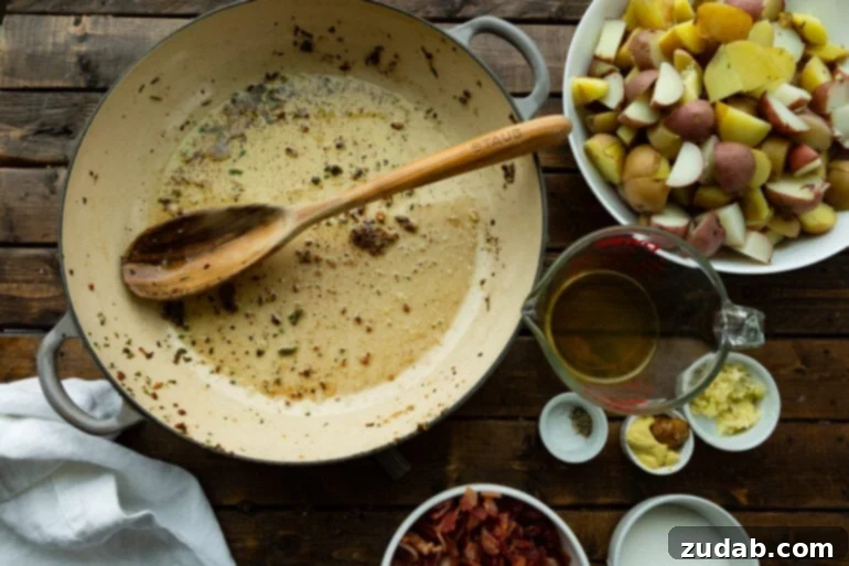 A photo of an empty Dutch oven, used for cooking bacon, with crispy bacon crumbles neatly placed on the side.