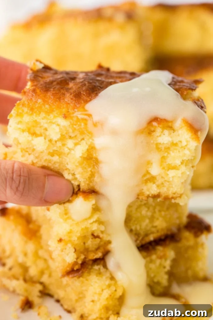 Honey Butter Bliss 3 A close-up of three stacked slices of sweet cornbread, generously coated with dripping honey butter, highlighting its moist texture.