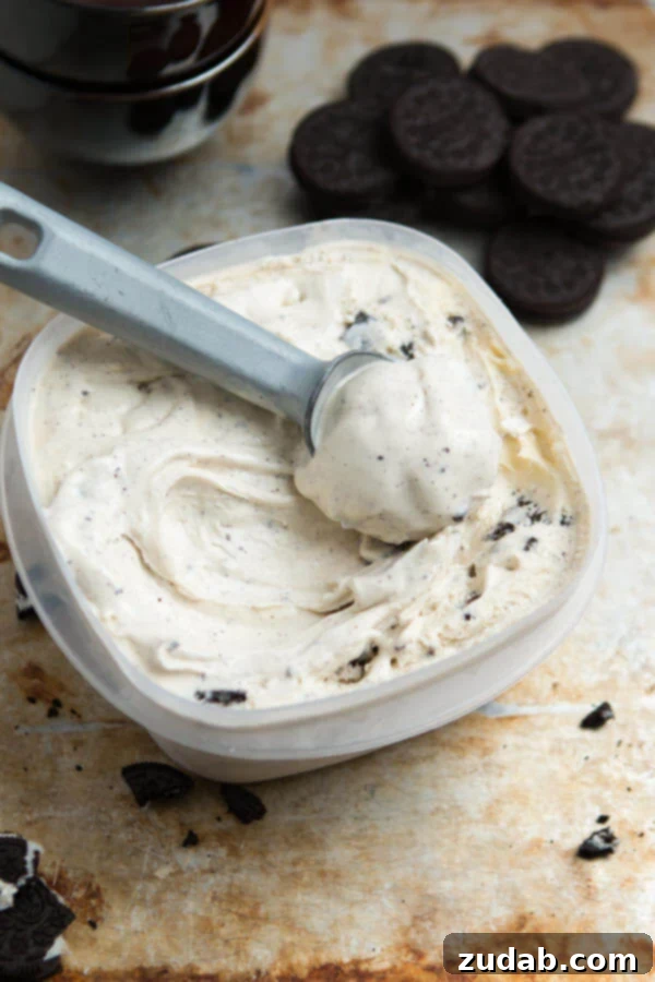 The creamiest and best homemade ice cream I have ever, ever made. Cookies and Cream Frozen Custard on ohsweetbasil.com Close-up of a scoop of rich, homemade Cookies and Cream Frozen Custard, showcasing its smooth texture and abundant Oreo chunks, a top recipe from Oh Sweet Basil.