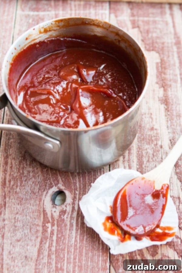 Homemade BBQ Sauce: Ready for Storage Glass jar filled with homemade BBQ sauce, showcasing its vibrant color and thick texture.
