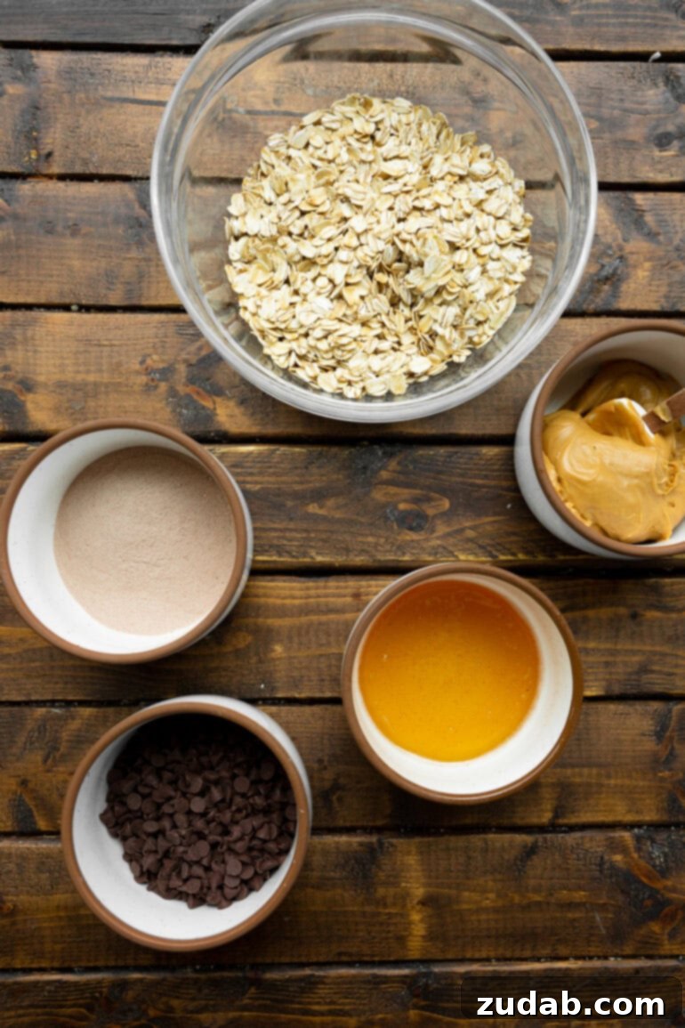 No-Bake Chocolate Protein Power Bites 4 All the essential ingredients for making oatmeal energy bites displayed in separate bowls, including oats, peanut butter, honey, and chocolate chips.