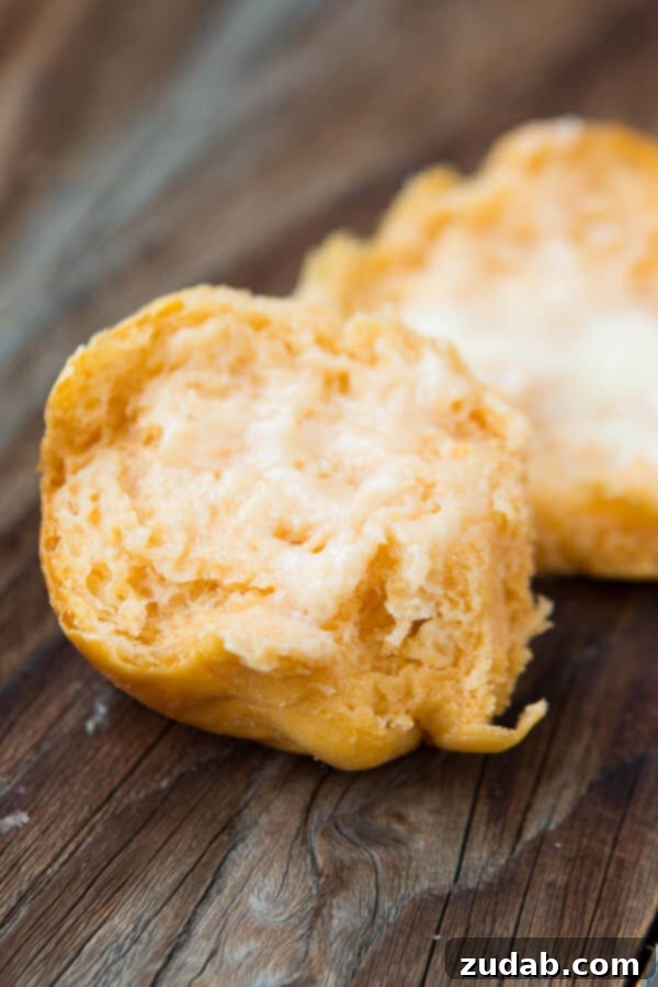 Achieve the Perfect Soft Texture with Our Sweet Potato Rolls A sweet potato roll sliced in half, revealing its soft, fluffy interior.