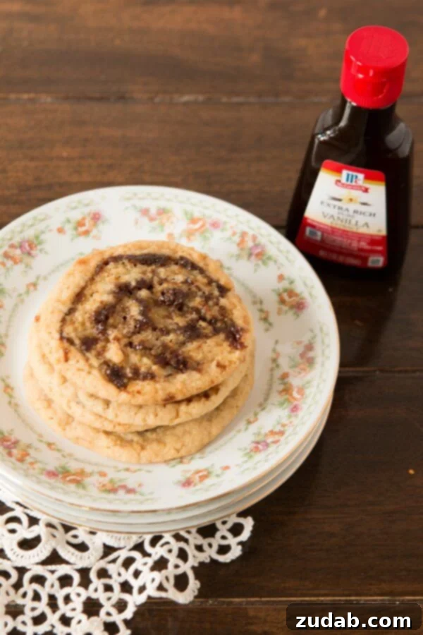 Grandma's cherished Pinwheel Cookies are the perfect blend of tradition and deliciousness. A beautifully arranged plate of Pinwheel Cookies next to a bottle of vanilla extract, ready for indulgence.