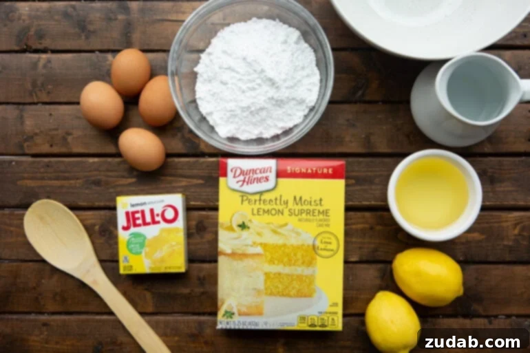 Zesty Lemon Cloud Cake 4 All the essential ingredients for making a delicious lemon jello cake, neatly laid out: a cake mix box, a packet of lemon jello, eggs, fresh lemons, and powdered sugar.