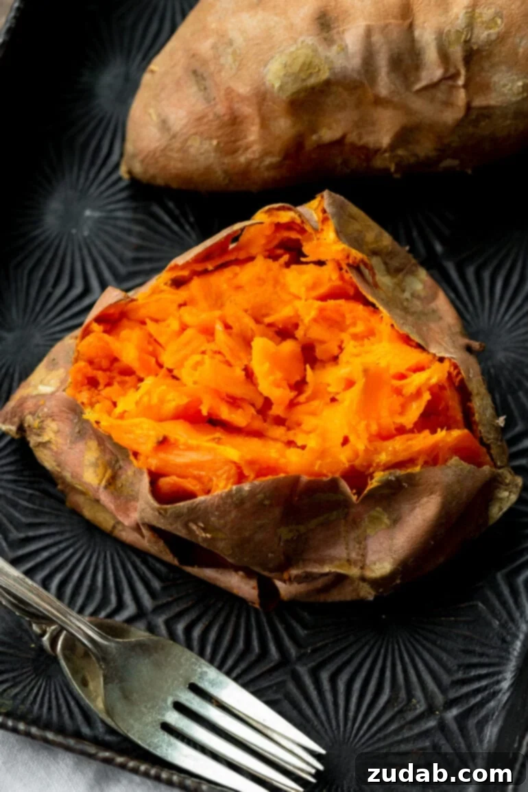 The Ultimate Homemade Texas Roadhouse Loaded Sweet Potato 4 A baked sweet potato, sliced open and mashed inside, revealing its tender, flavorful interior.