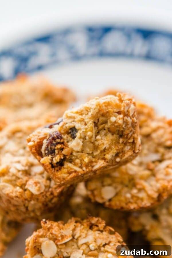 Have you ever had those Aussie Bites from Costco? They are such a great healthy snack on the go and now you can try our Aussie Bites Copycat Recipe! a photo of the cross section of an aussie bite that has been broken in half sitting on top of several whole ones
