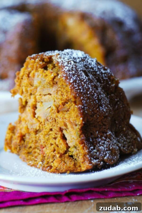 Moist Apple-Pumpkin Spice Bundt Cake with Natural Sweetness Close-up of a slice of Apple-Pumpkin Spice Bundt Cake, showing chunks of apple