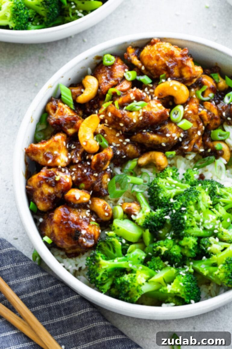 Effortless Cashew Chicken 3 A photo of saucy chicken bites mixed with cashews and steamed broccoli, ready to be served.