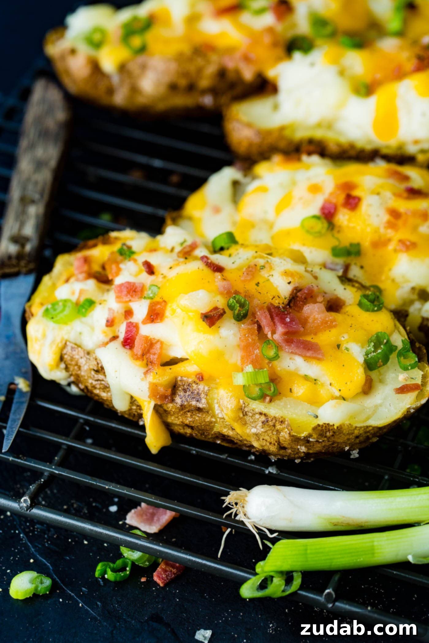 Twice-Baked Potato Perfection 3 a cooling rack with a line up of twice baked potatoes loaded with bacon and cheese