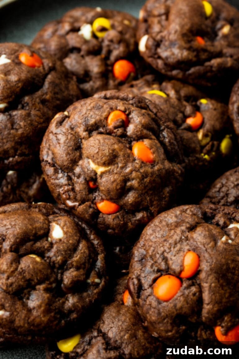 Reese's Triple Chocolate Cookies 5 A photo of several thick and wonderfully chewy Reese's Triple Chocolate Cookies piled high on a wire cooling rack, ready to be enjoyed.