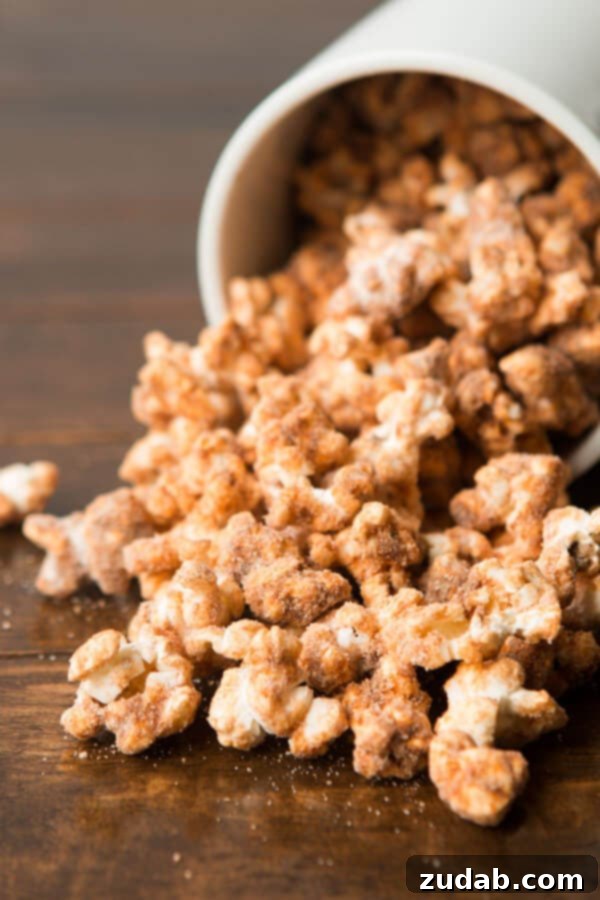 Grab a Handful of Churro Popcorn Two hands reaching into a vibrant blue bowl filled with churro popcorn, highlighting the snack's irresistible appeal.
