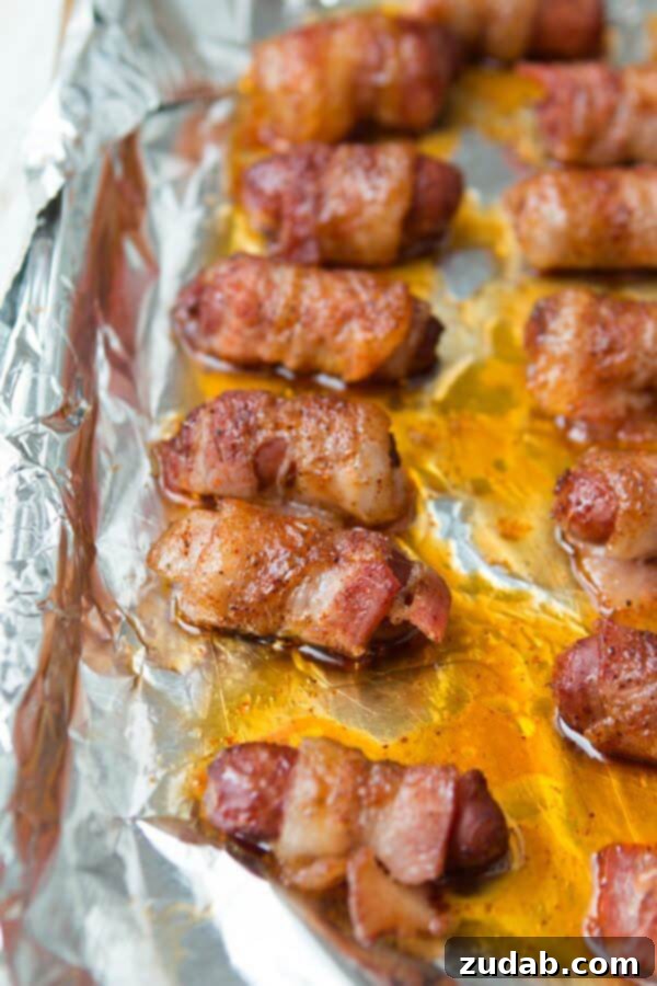 Delicious bacon-wrapped little smokies on a foil-lined baking tray, ready to be served as a party appetizer.