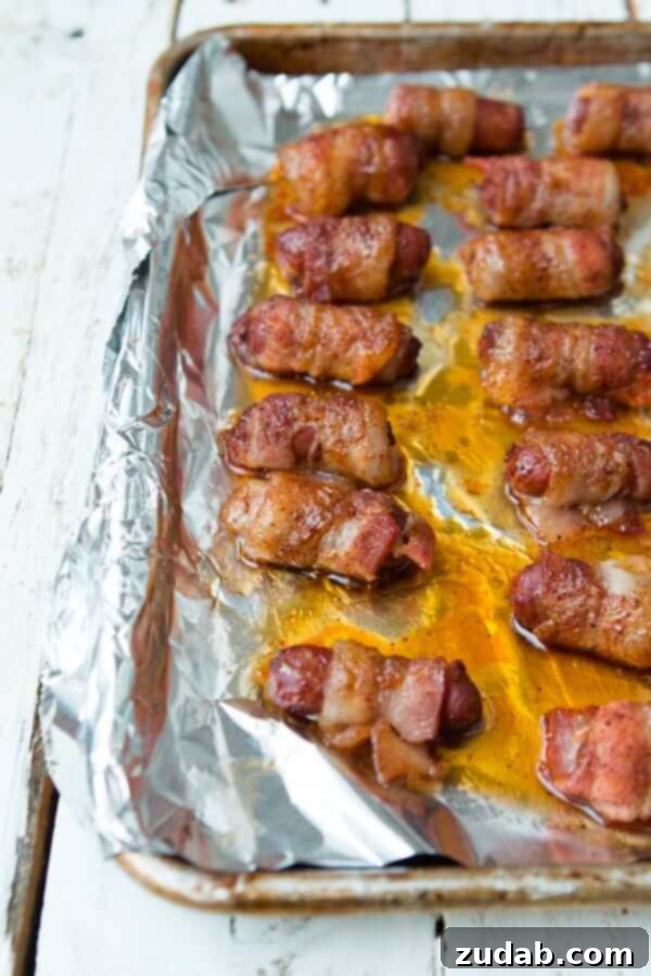 A festive platter of sweet and savory bacon-wrapped little smokies, garnished and ready for a party.