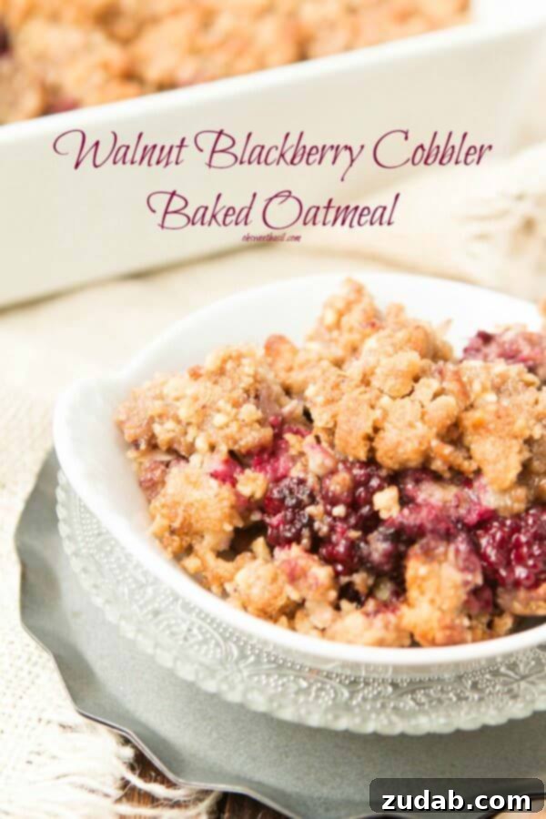 A closer look at the rich texture of blackberry cobbler baked oatmeal with a golden walnut crumble. Blackberry cobbler baked oatmeal with walnut crumble. It's like dessert for breakfast but way healthier. ohsweetbasil.com