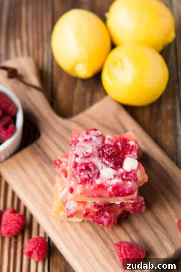 My new favorite Raspberry Lemon Tart Bars Two square raspberry lemon bars stacked on each other, viewed from above