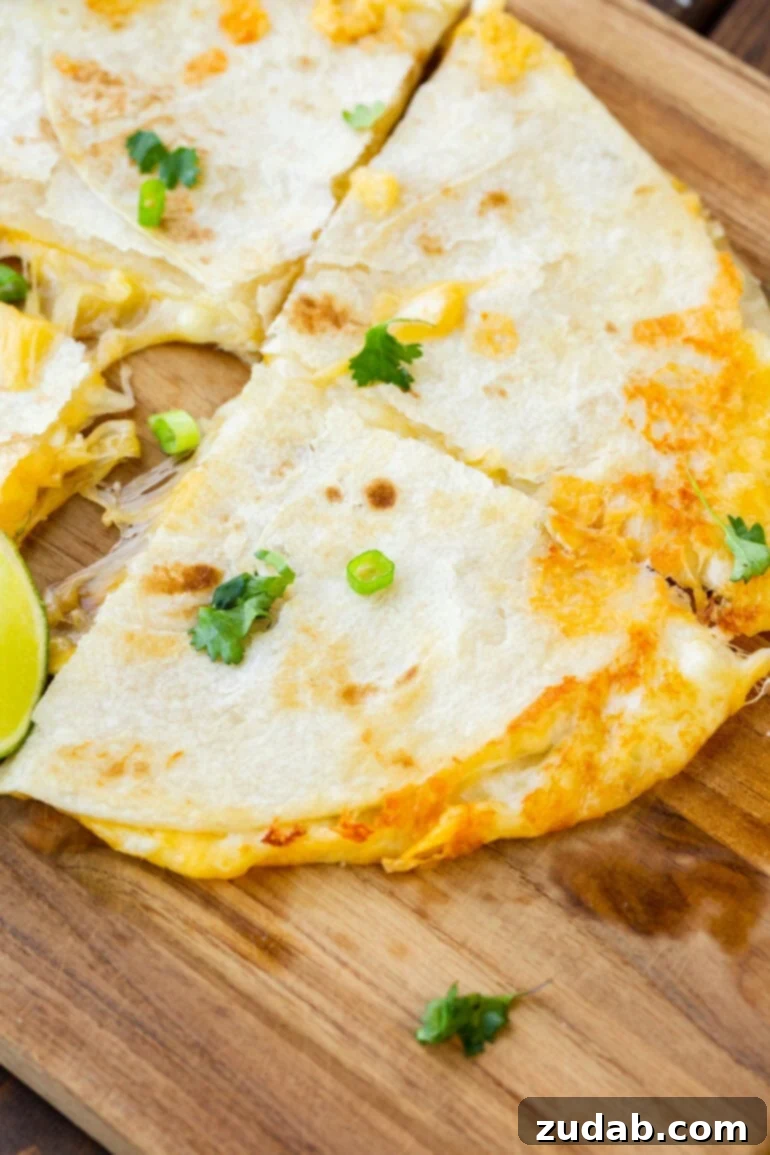 Unlocking Quesadilla Perfection 2 A golden cooked quarter of a cheese quesadilla with rich, melted cheese oozing out the sides, showcasing the perfect texture and deliciousness of the best homemade quesadilla.