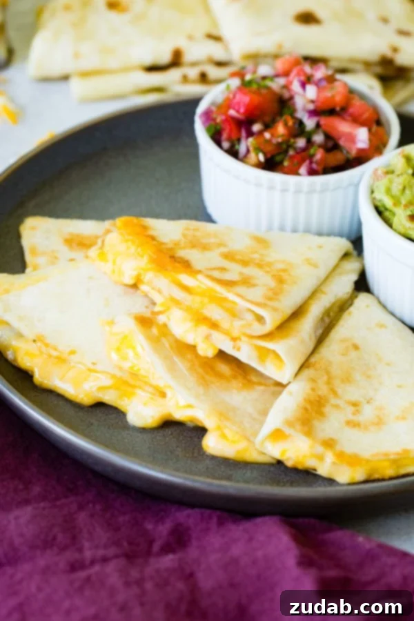 Secrets to the Best Quesadilla A stack of cheese quesadilla pieces, with rich, melted cheese visibly oozing out, accompanied by bowls of fresh pico de gallo and guacamole in the background.
