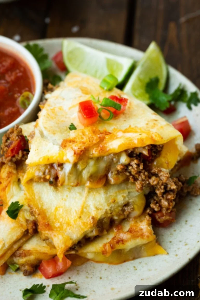 Unlocking Quesadilla Perfection 7 A stack of cheesy ground beef quesadilla pieces, cut into quarters, showing the rich filling and golden tortilla, perfect for a hearty meal.