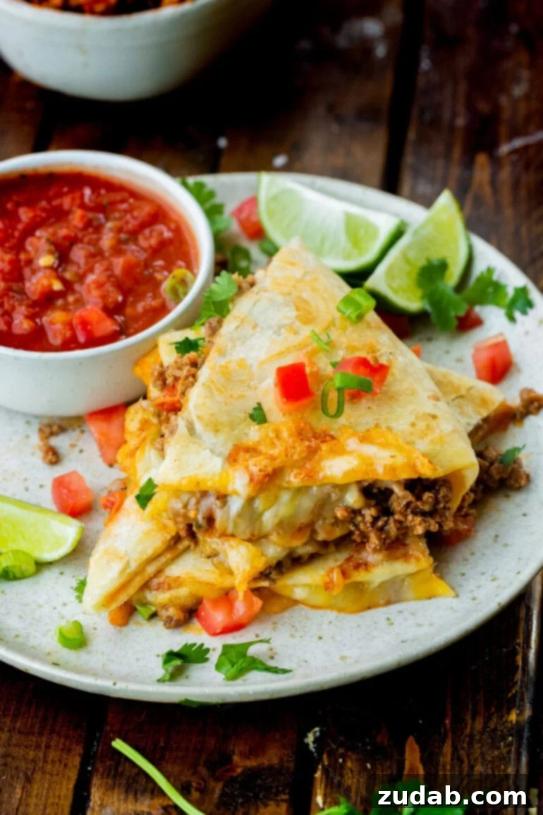 Unlocking Quesadilla Perfection 10 A stack of cheese and ground beef quesadilla pieces arranged next to a small bowl of vibrant salsa, presenting a complete and appealing meal.