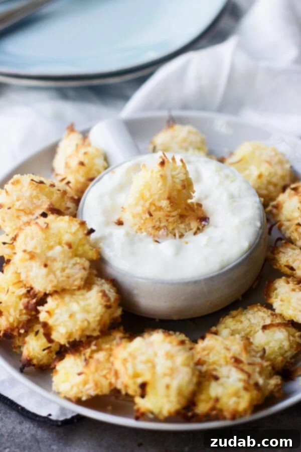 Crispy Baked Coconut Shrimp Ready to Dip Close-up of golden Baked Coconut Shrimp on a plate