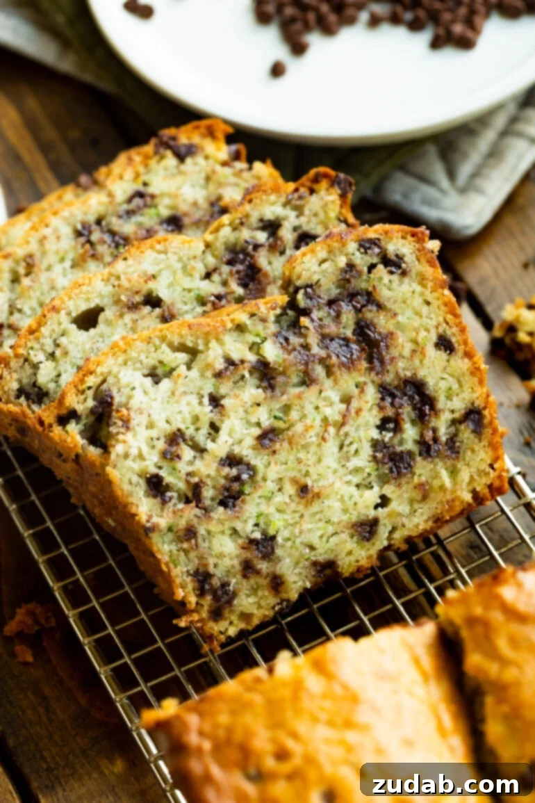 Decadent Chocolate Chip Zucchini Banana Bread 2 A photo of three thick slices of banana zucchini bread that are loaded with chocolate chips and tipped onto each other, showcasing the moist texture.