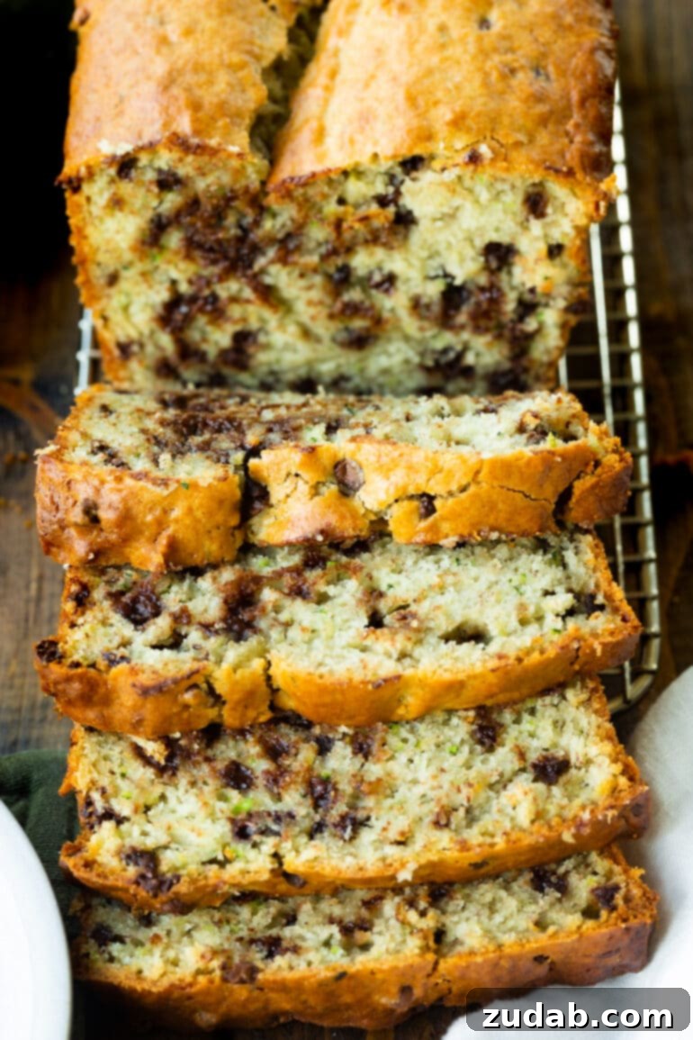 Decadent Chocolate Chip Zucchini Banana Bread 3 A photo of a loaf of banana zucchini bread loaded with chocolate chips and several slices cut from the loaf and laying on each other, ready to be served.
