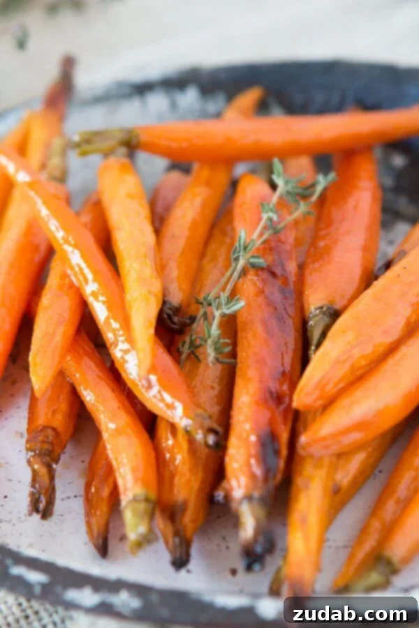 Our family's favorite side, honey roasted carrots. ohsweetbasil.com A close-up of tender, golden honey roasted carrots, glistening with a sweet garlic butter glaze. ohsweetbasil.com