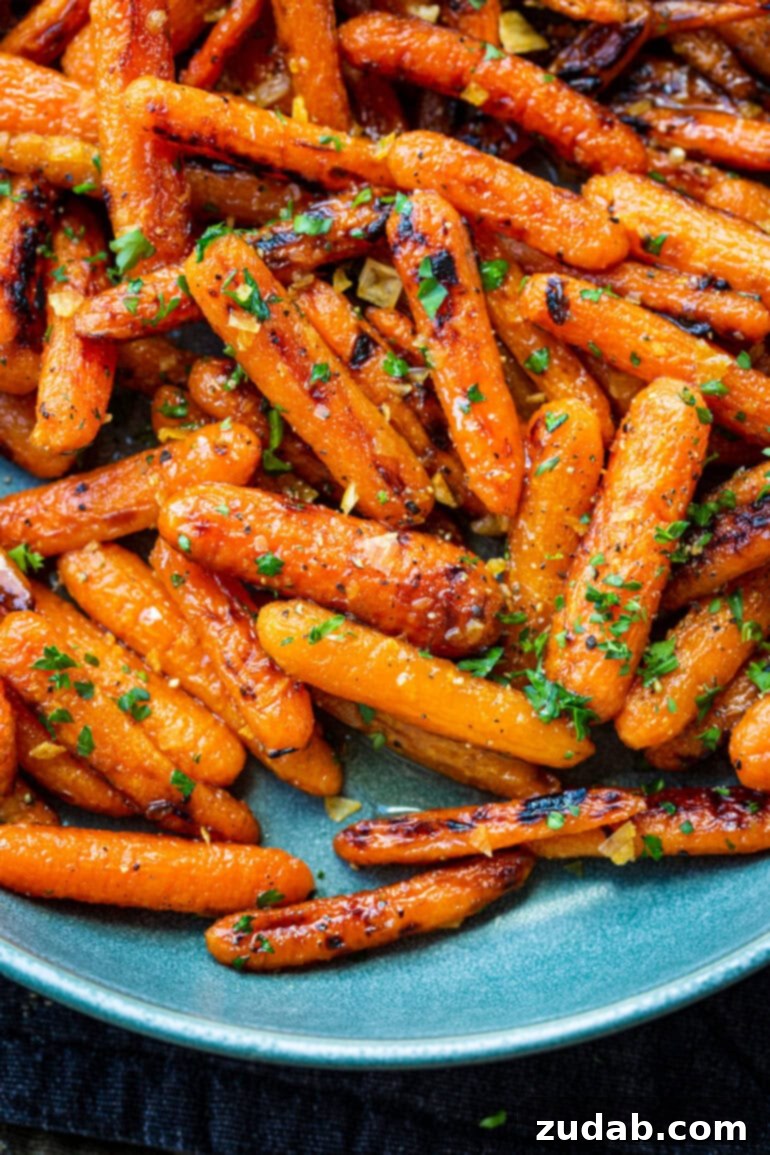 Golden Honey Garlic Roasted Carrots 5 A close-up of beautifully roasted honey glazed baby carrots, generously topped with vibrant chopped parsley and fragrant minced garlic.