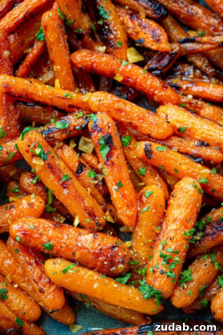 Golden Honey Garlic Roasted Carrots 6 A vibrant photo of roasted honey glazed baby carrots, garnished with fresh chopped parsley and fragrant minced garlic, ready to be served.