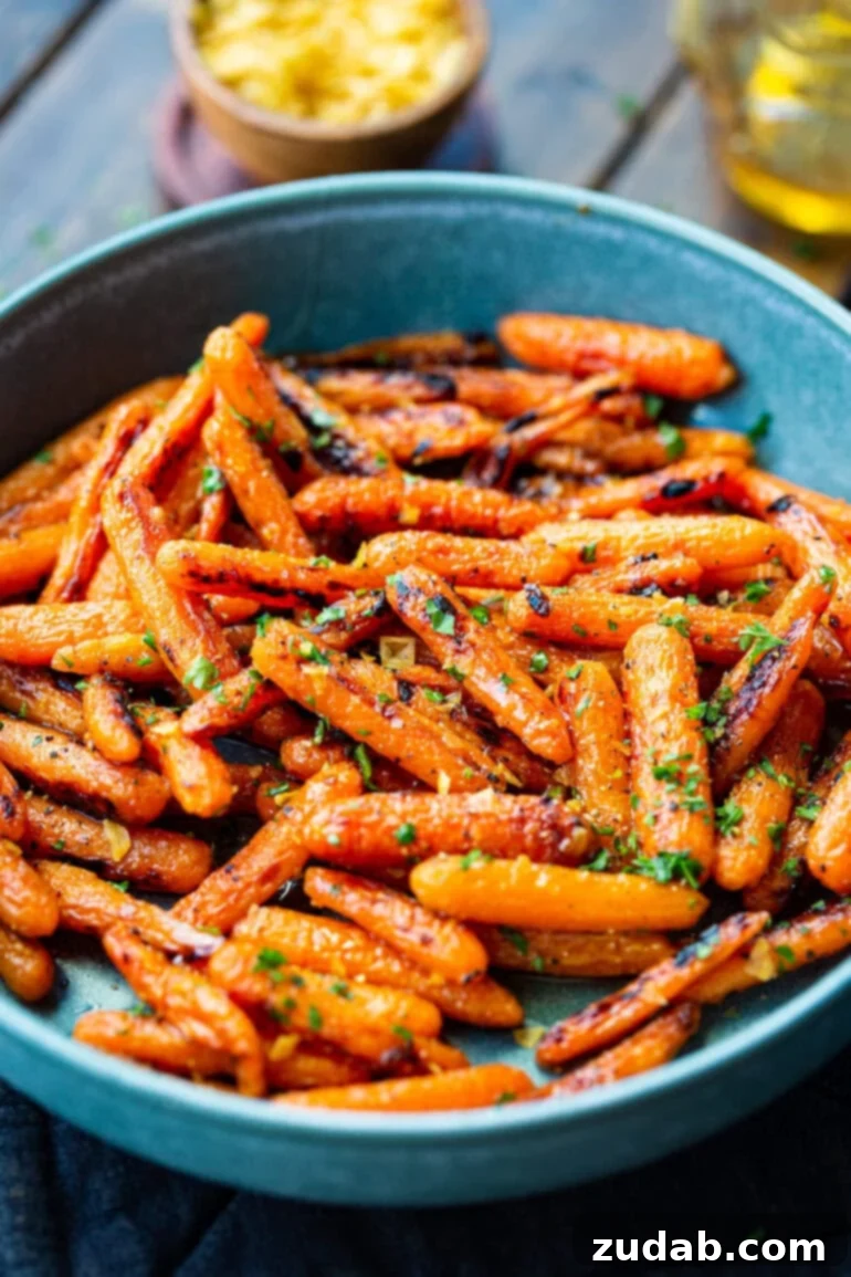 Golden Honey Garlic Roasted Carrots 7 A generously sized blue serving bowl, brimming with honey garlic roasted baby carrots, beautifully adorned with a sprinkle of chopped fresh herbs for a vibrant finish.