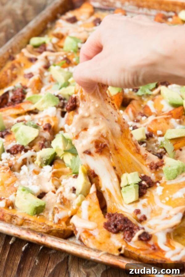 Irresistible Chorizo Loaded Cheesy Potatoes with fresh toppings. Chorizo Loaded Cheesy Potatoes ready to be served.
