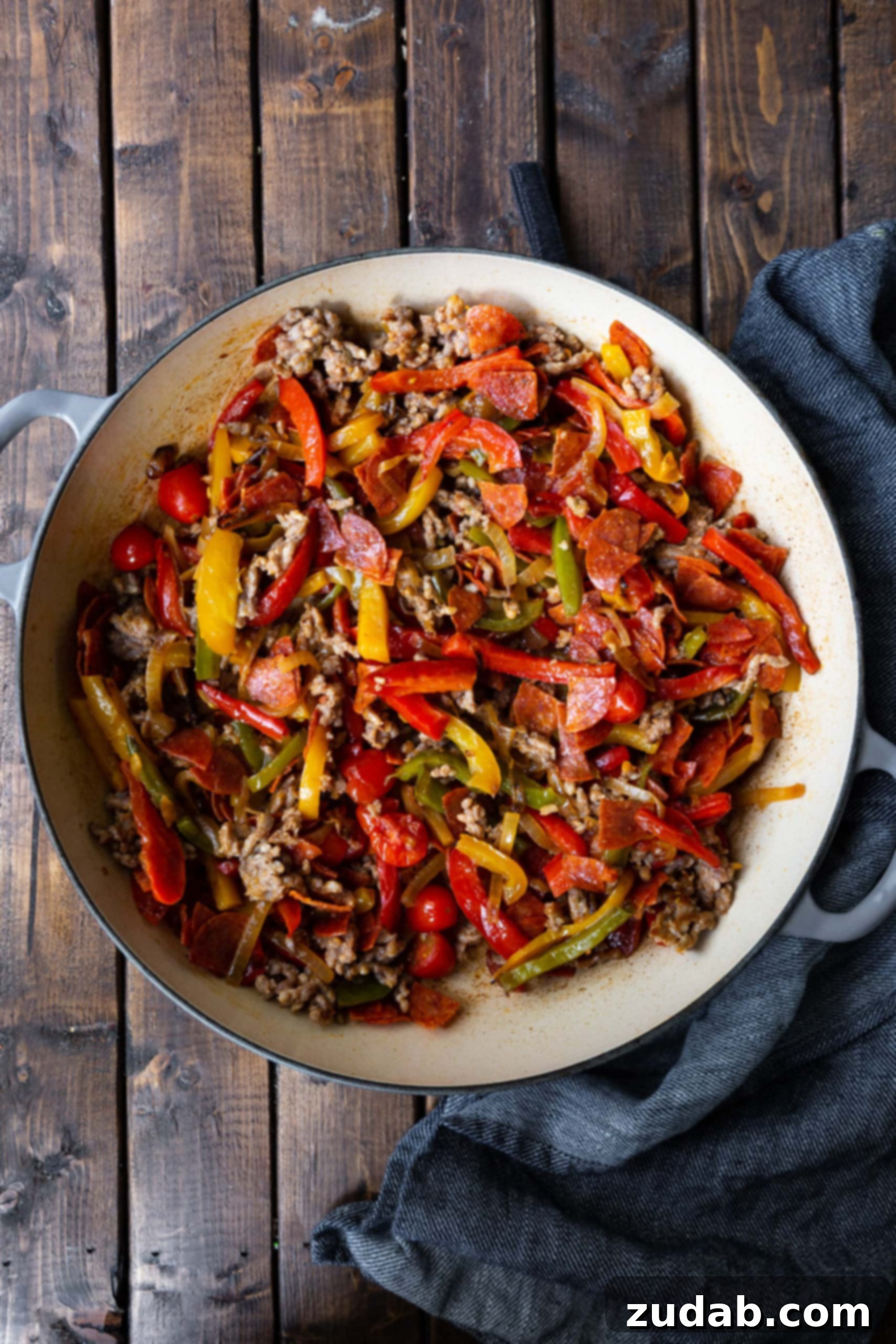 Ultimate Italian Sausage and Peppers Rigatoni A close-up shot of perfectly cooked Italian sausage mixed with sweet caramelized bell peppers and onions, ready to be combined with rigatoni for a hearty pasta dish.