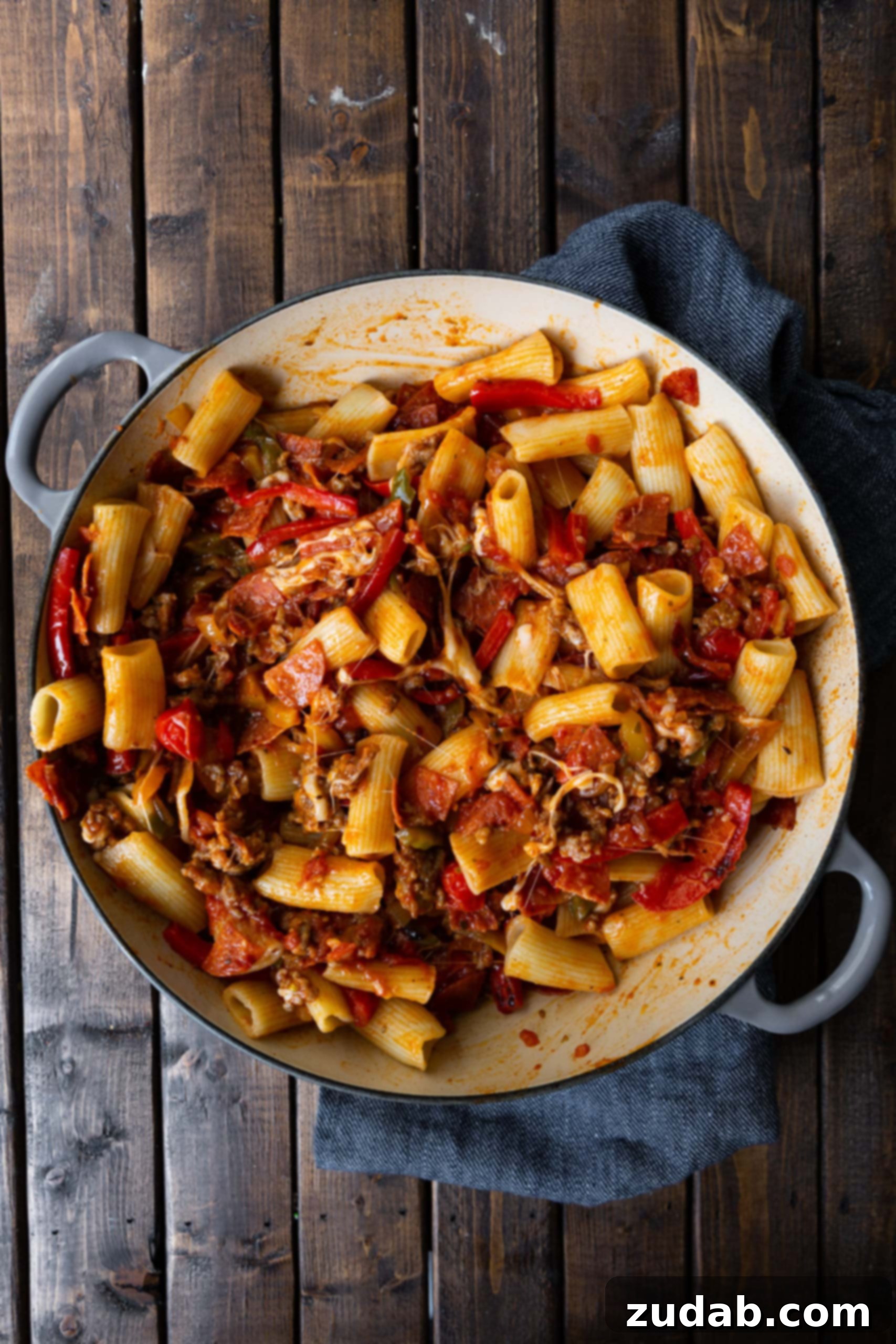Ultimate Italian Sausage and Peppers Rigatoni A vibrant close-up of cooked rigatoni pasta perfectly mixed with rich caramelized peppers and onions, savory chopped pepperoni, and beautifully browned Italian sausage, ready to be sauced.