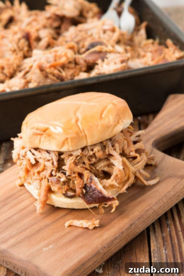 Want to make the best pulled pork from your own kitchen? This recipe for the world's best Carolina pulled pork all starts with a brine. best pulled pork sandwich on wooden serving board with sides