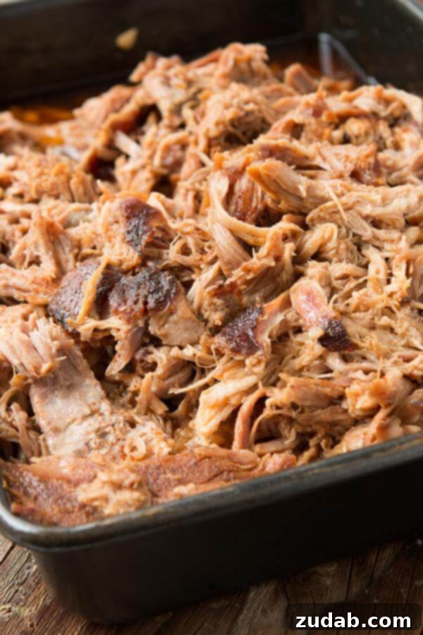 Want to make the best pulled pork from your own kitchen? This recipe for the world's best Carolina pulled pork all starts with a brine. Carolina pulled pork in metal baking dish, shredded and ready to serve