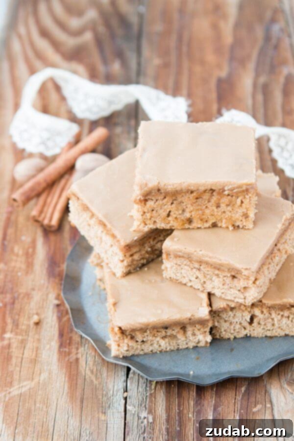 Perfectly Moist Spice Cake with Maple Frosting A close-up shot of a slice of spice cake generously topped with creamy maple frosting, highlighting the perfect texture. ohsweetbasil.com