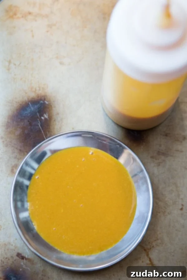 Essential Carolina BBQ Sauces: Mustard and Vinegar Varieties. A side-by-side display of Carolina Mustard BBQ Sauce and Carolina Vinegar Sauce in clear glass jars.