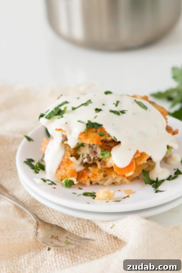 Crispy on the outside, cheesy and savory on the inside: homemade cheesy ground beef and rice fried cakes topped with a quick, creamy white sauce. ohsweetbasil.com