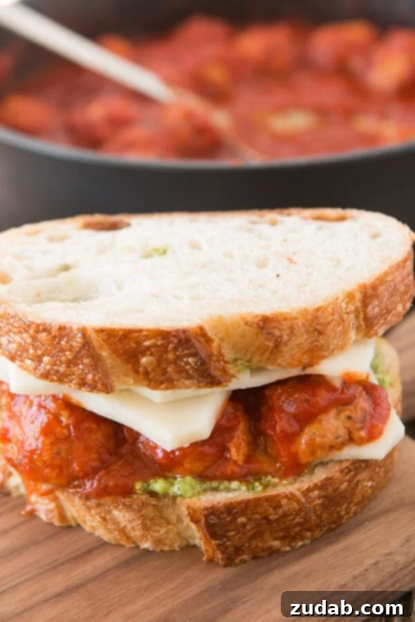 Assembling the Pesto Meatball Panini with perfectly sauced Johnsonville meatballs, fresh pesto, and generous slices of mozzarella cheese.