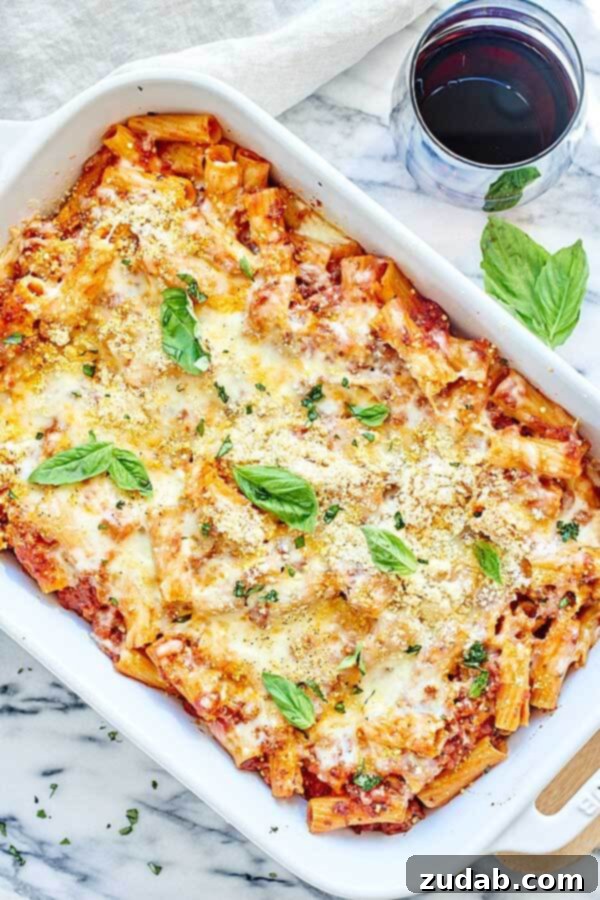 Hearty Baked Pasta with Spicy Sausage Marinara Delicious Spicy Sausage Rigatoni baking in a casserole dish, topped with bubbling melted mozzarella, promising a cozy and hearty meal perfect for any occasion.
