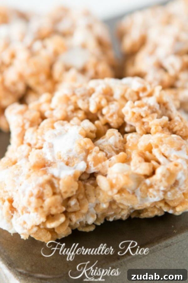 Gooey Fluffernutter Rice Krispies: The Ultimate No-Bake Peanut Butter Marshmallow Treat Freshly made Fluffernutter Rice Krispies treats cooling, ready for a taste of pure nostalgia.