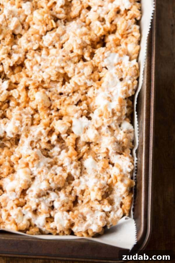 Gooey Fluffernutter Rice Krispies: The Ultimate No-Bake Peanut Butter Marshmallow Treat Enjoying a warm piece of Gooey Fluffernutter Rice Krispies, a truly comforting dessert.