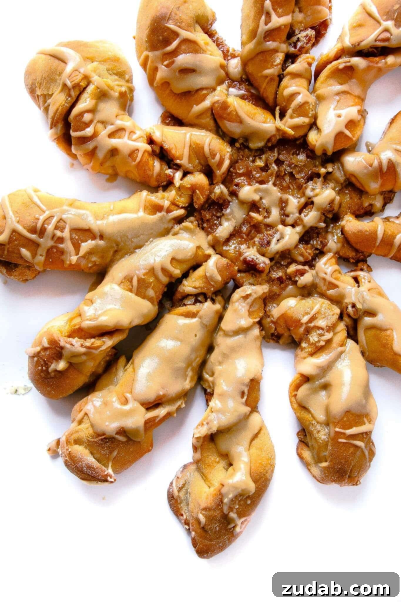 Decadent Maple Twists Close-up of fluffy maple cinnamon roll twists drenched in glaze. A truly heavenly breakfast treat.