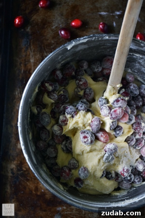 Filling bundt pan with cranberry cake batter Cranberry Bundt Cake batter being spooned into a prepared bundt pan.
