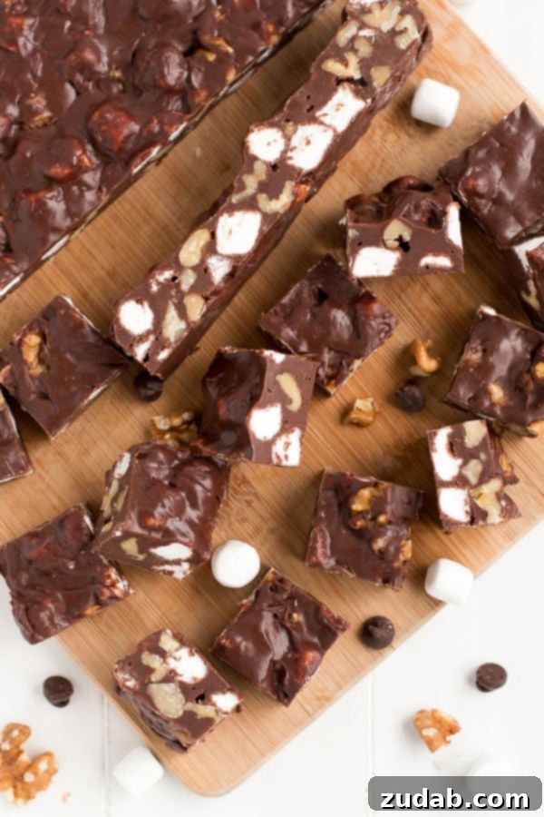Master this quick and easy Rocky Road Fudge recipe in under 10 minutes! Close-up of decadent Rocky Road Fudge squares, showcasing marshmallows, walnuts, and rich chocolate.