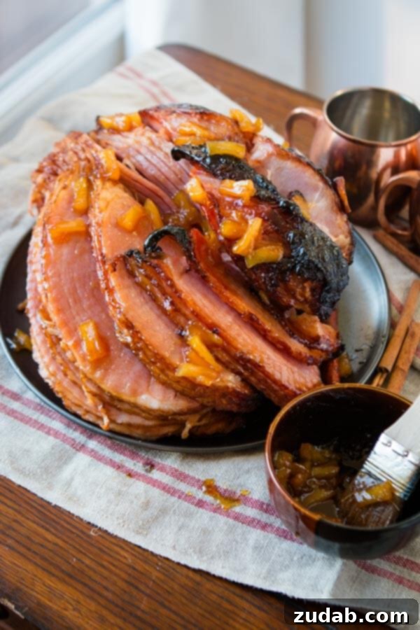 The World's Best Brown Sugar Ham, perfect for any occasion, ready to be enjoyed with complementary dipping sauces. A close-up of beautifully sliced brown sugar ham, generously coated in its sweet glaze, with small cups of Honey Mustard and Pina Colada dipping sauces on the side.